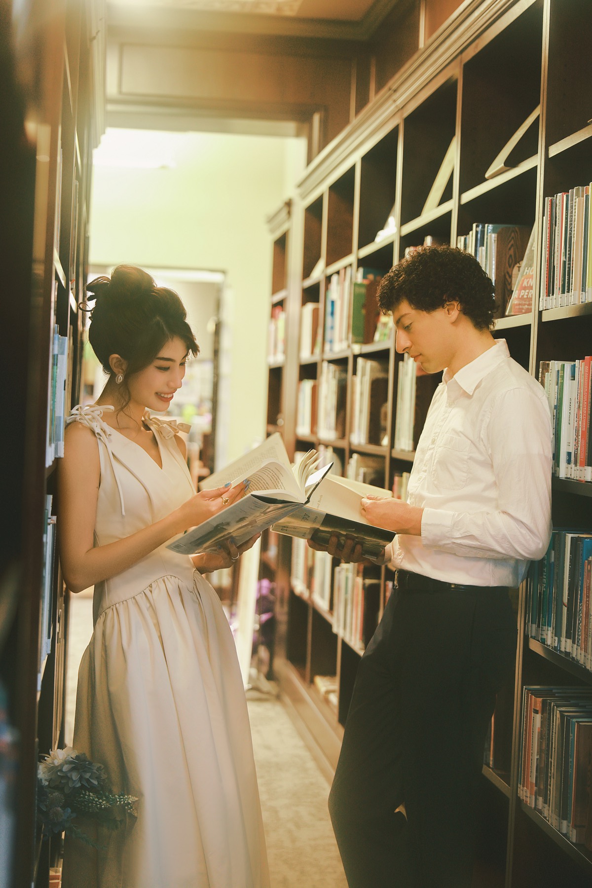 Couple reading a book together in a library