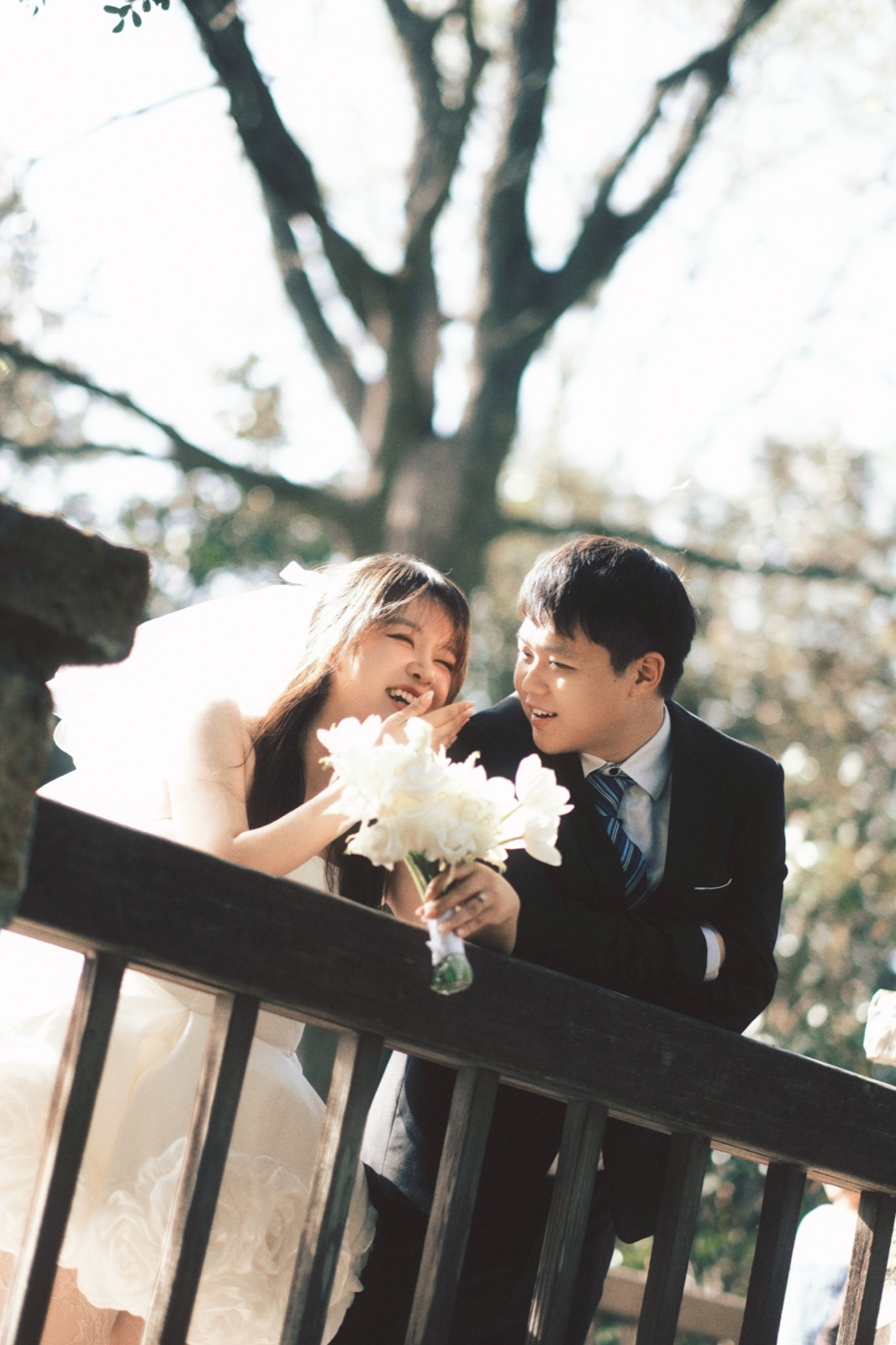 Bride and groom laughing over a bouquet