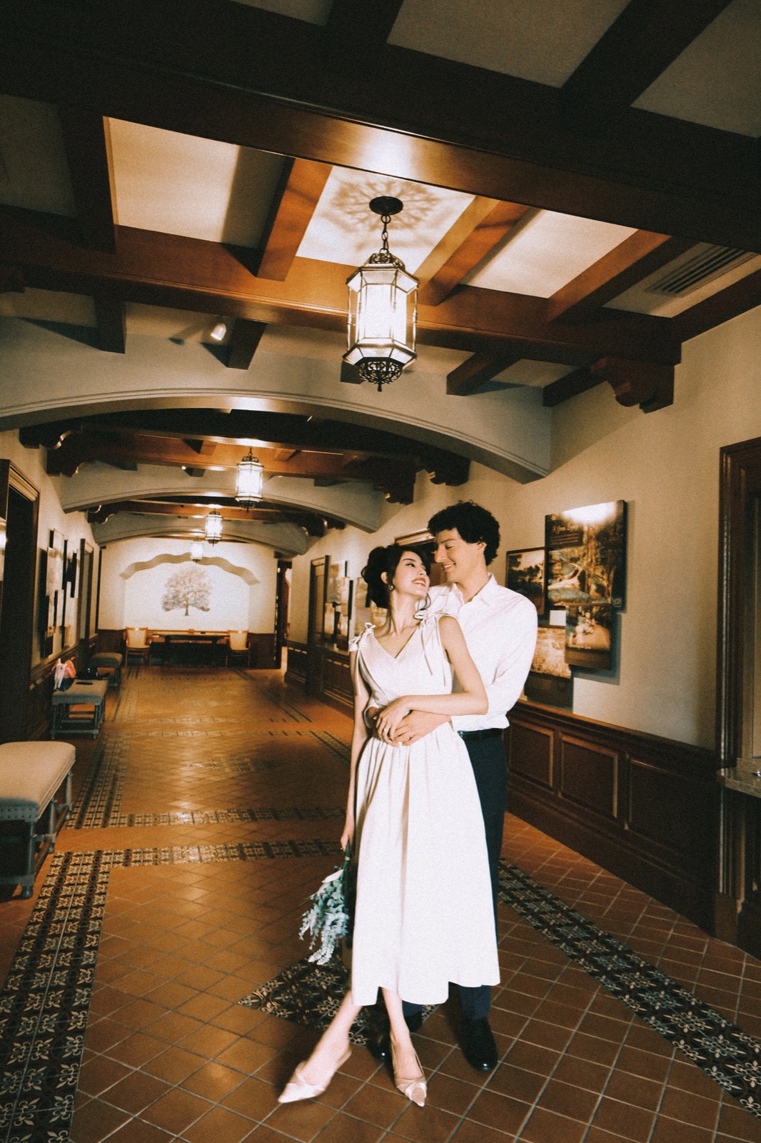 Couple embracing in a tiled hallway