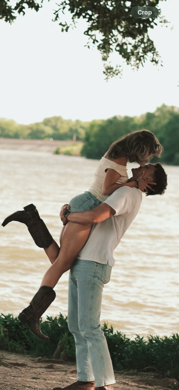 Couple kissing by a riverbank