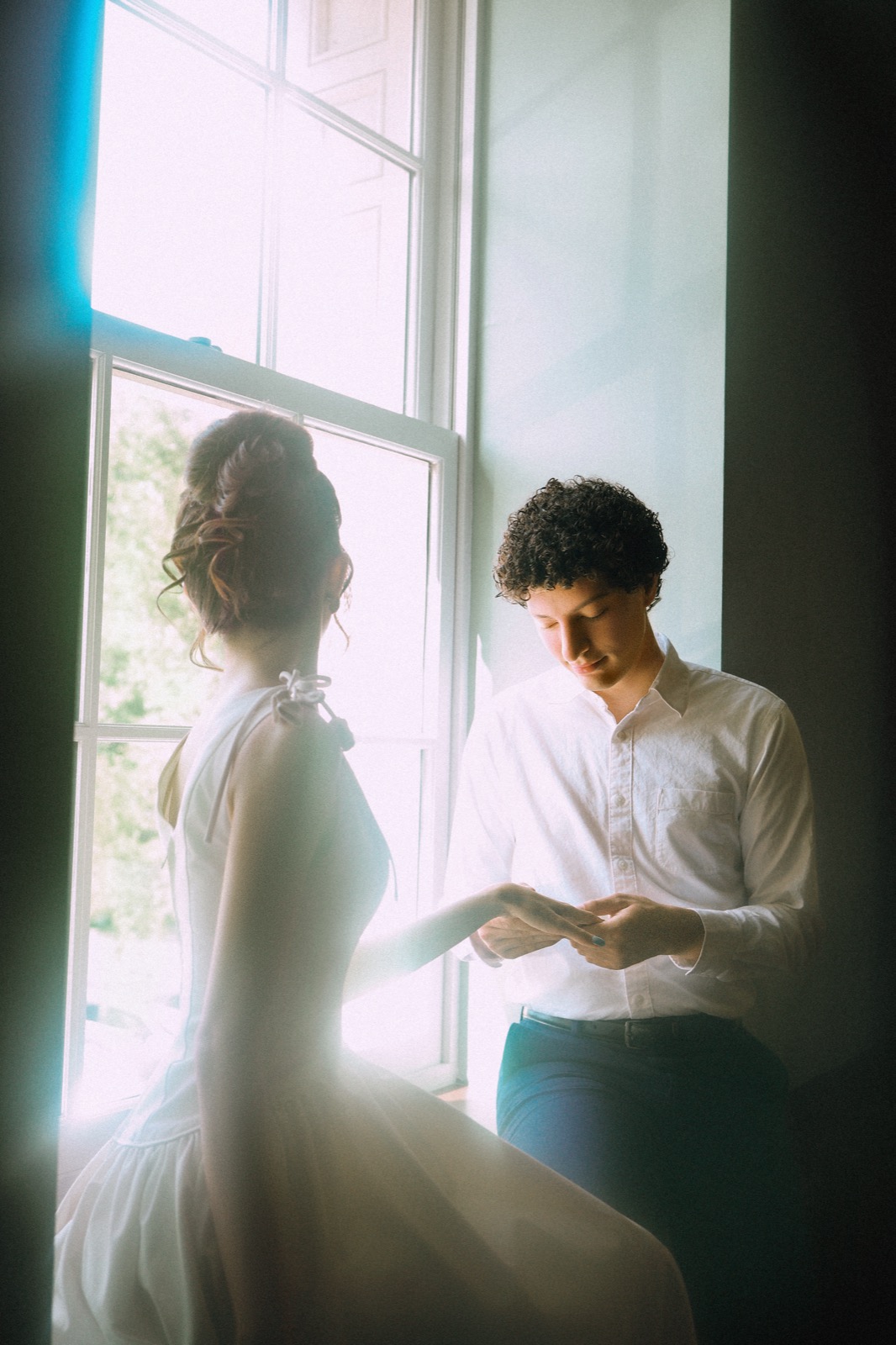Bride and groom by a bright window