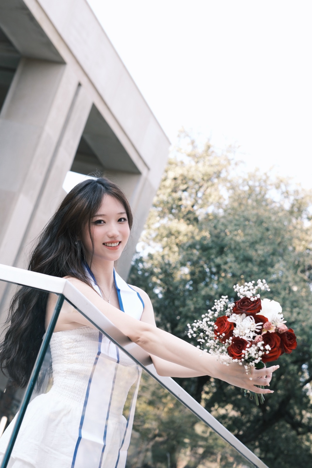 Graduate holding a rose bouquet