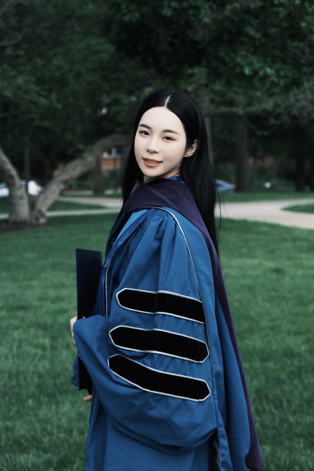Graduate in doctoral gown on the lawn